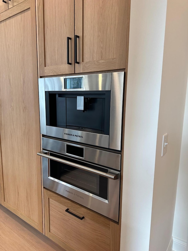 details featuring stainless steel double oven and light brown cabinets