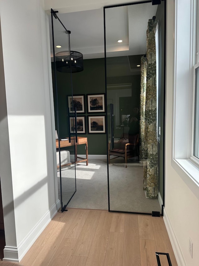 interior space with baseboards, wood finished floors, and recessed lighting