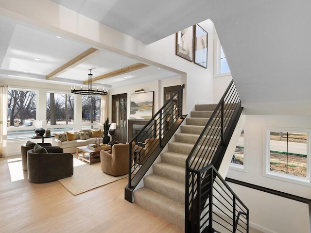 interior space featuring a chandelier, beamed ceiling, and wood finished floors