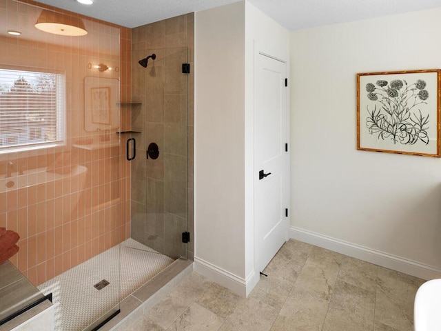 bathroom featuring a shower stall and baseboards