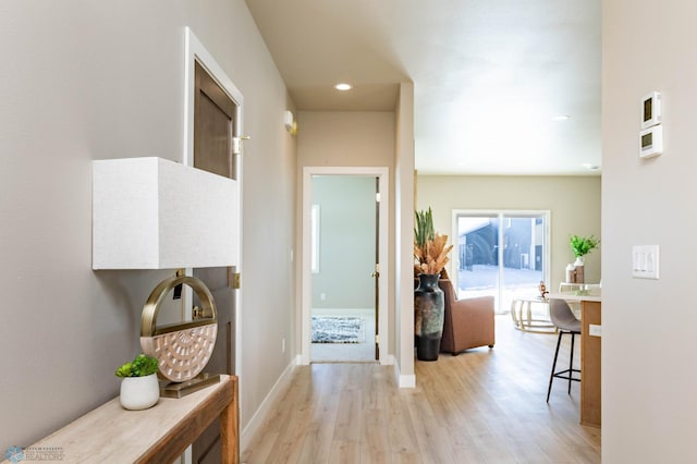 hallway featuring light wood-style floors, recessed lighting, and baseboards