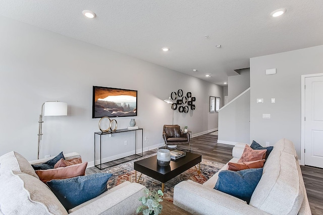 living room featuring baseboards, dark wood-style flooring, a textured ceiling, and recessed lighting