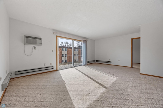 empty room featuring light carpet, baseboards, a textured ceiling, a baseboard heating unit, and a wall mounted AC