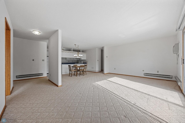 unfurnished living room featuring a textured ceiling, a baseboard radiator, a notable chandelier, and baseboards