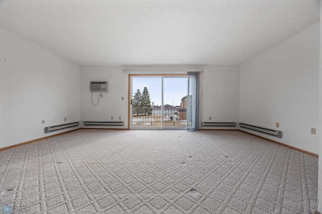 empty room with carpet, a wall unit AC, a textured ceiling, and baseboards