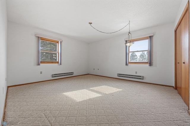 unfurnished room featuring a baseboard heating unit, baseboards, and light colored carpet