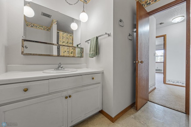 bathroom with visible vents, vanity, baseboards, and a textured ceiling