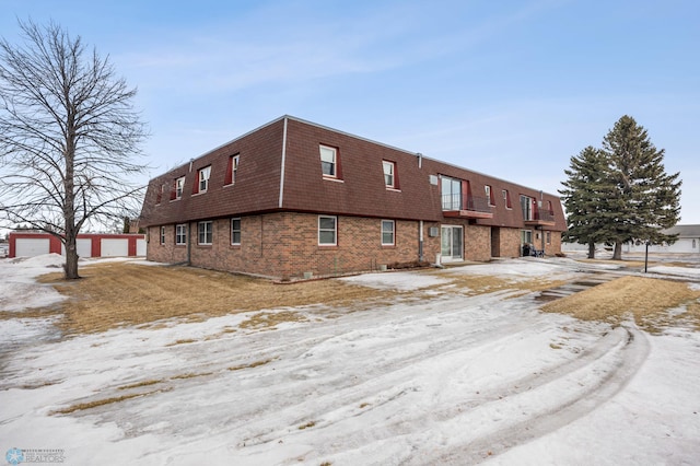 snow covered property featuring a detached garage