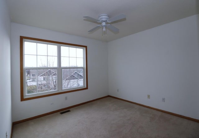 empty room with a ceiling fan, carpet, visible vents, and baseboards