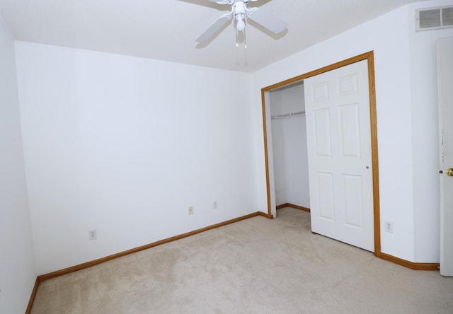 unfurnished bedroom featuring ceiling fan, light colored carpet, visible vents, baseboards, and a closet