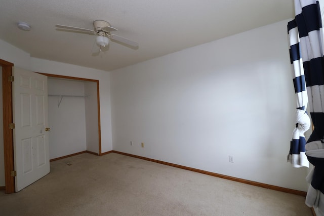 unfurnished bedroom featuring a closet, carpet, a ceiling fan, and baseboards