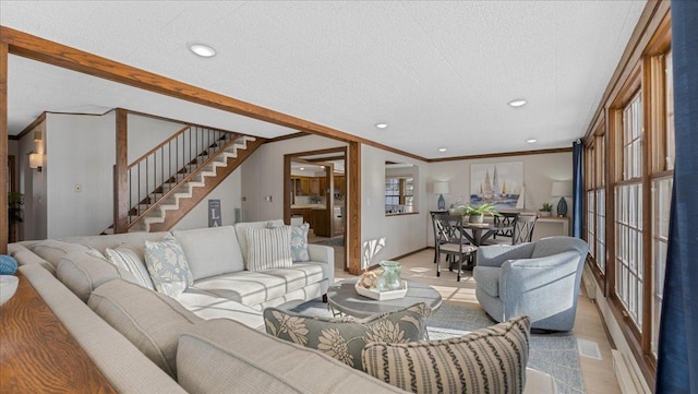 living room featuring baseboards, stairway, ornamental molding, a textured ceiling, and recessed lighting