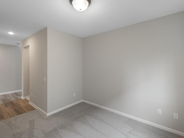 carpeted empty room with a textured ceiling