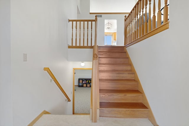 stairway with a towering ceiling and visible vents
