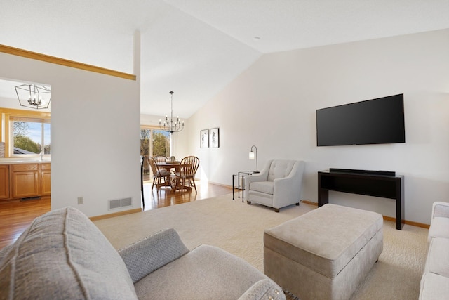 living area featuring a notable chandelier, lofted ceiling, a wealth of natural light, and visible vents