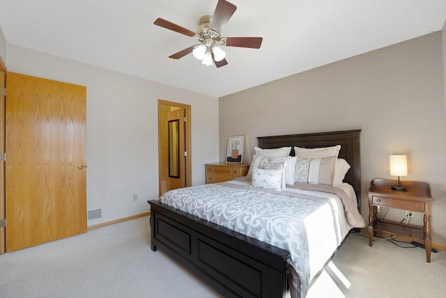 bedroom featuring baseboards, visible vents, light carpet, and ceiling fan