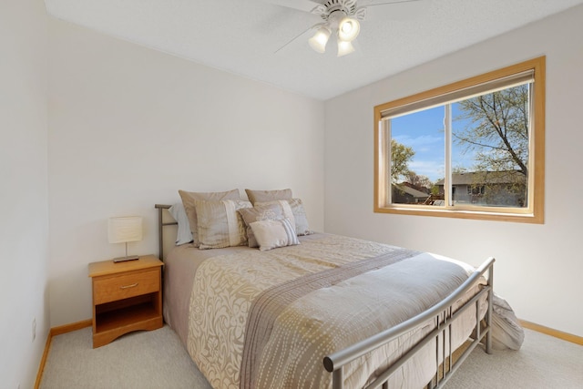 bedroom with baseboards, light carpet, and a ceiling fan