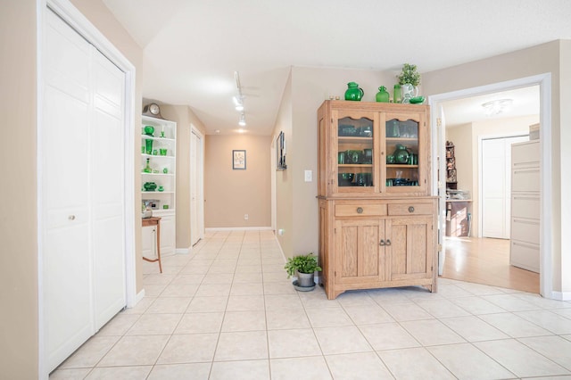 kitchen with light tile patterned floors, light brown cabinets, and baseboards