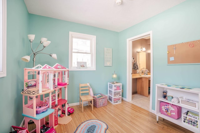 recreation room with baseboards and wood finished floors