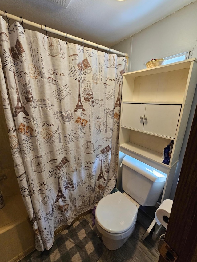 full bathroom featuring a shower with shower curtain and toilet