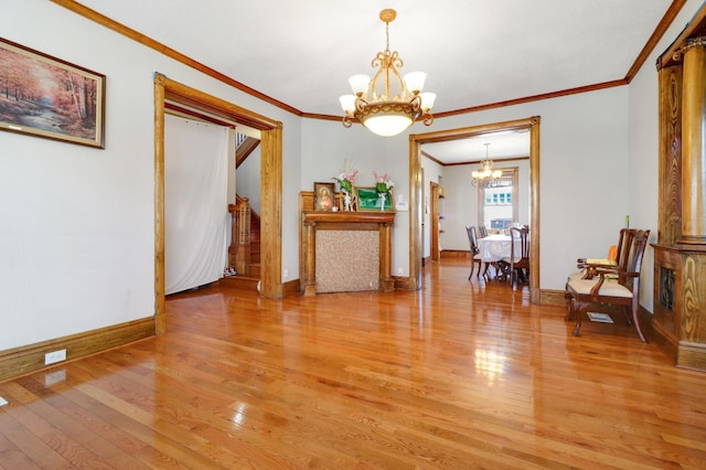 dining space with light wood-type flooring, baseboards, crown molding, and an inviting chandelier