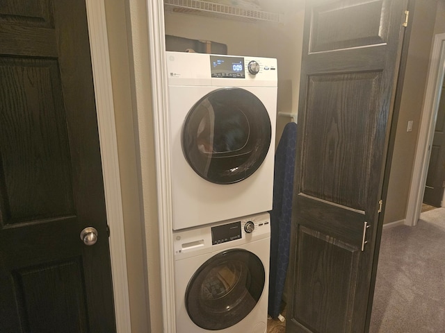 washroom featuring laundry area, stacked washer / dryer, and carpet flooring