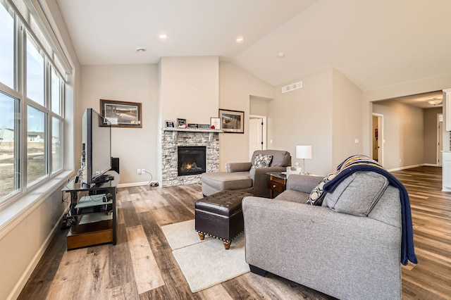 living room with wood finished floors, a fireplace, visible vents, and baseboards