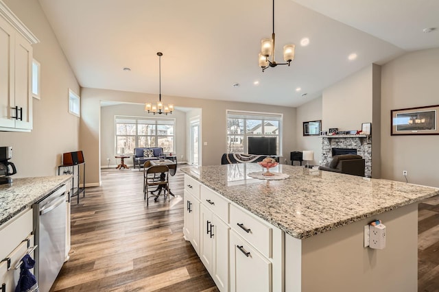 kitchen featuring a notable chandelier, dishwasher, open floor plan, and vaulted ceiling