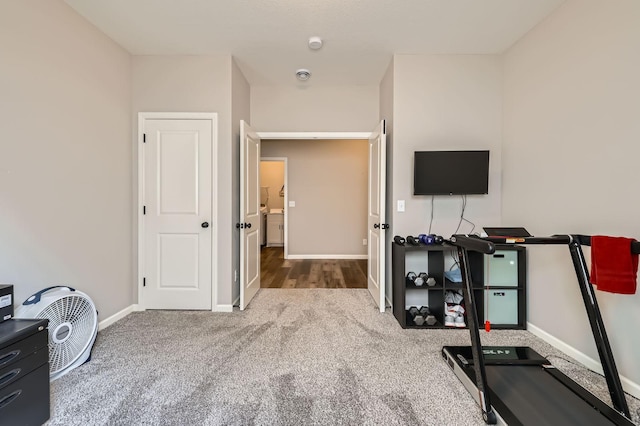 exercise room featuring baseboards and carpet floors