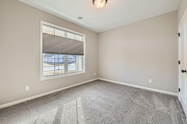 carpeted empty room with baseboards