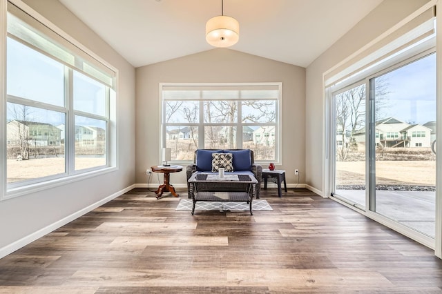 living area with lofted ceiling, wood finished floors, and baseboards