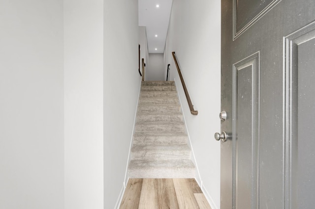 stairway with recessed lighting and wood finished floors