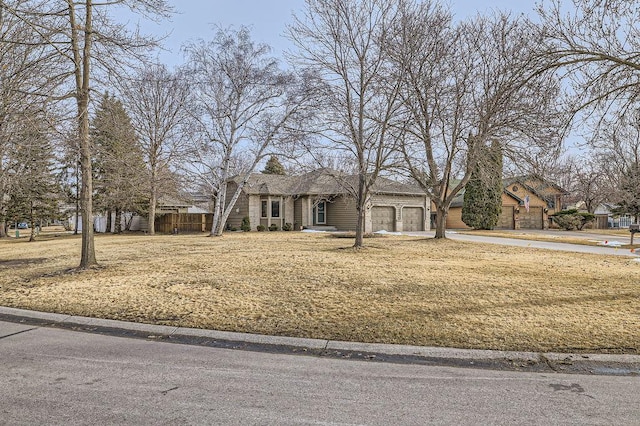 view of front of home with concrete driveway, fence, and a garage