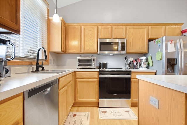 kitchen featuring a toaster, stainless steel appliances, a sink, light countertops, and pendant lighting