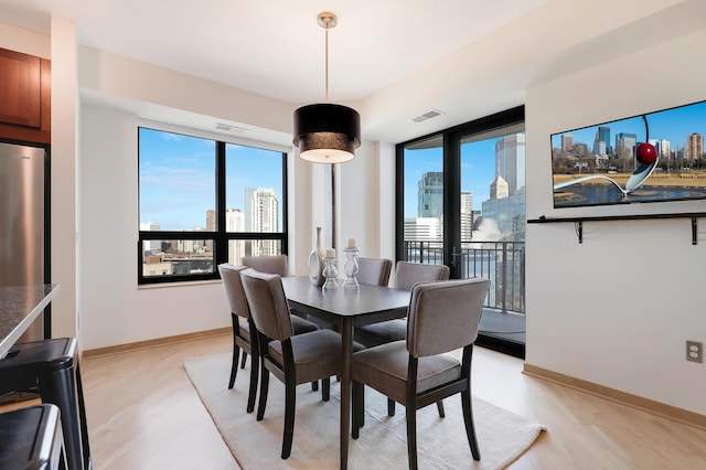 500 Grant St Unit 1302, Minneapolis, MN 55404 - dining space with visible vents, light wood finished floors, and a wealth of natural light