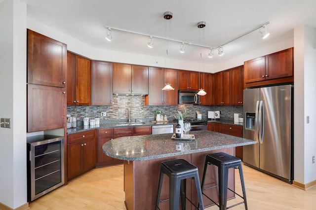 500 Grant St Unit 1302, Minneapolis, MN 55404 - kitchen with wine cooler, a kitchen bar, a sink, light wood-style flooring, and stainless steel appliances
