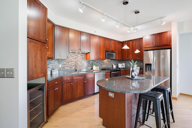 500 Grant St Unit 1302, Minneapolis, MN 55404 - kitchen featuring appliances with stainless steel finishes, a kitchen bar, backsplash, wine cooler, and a kitchen island
