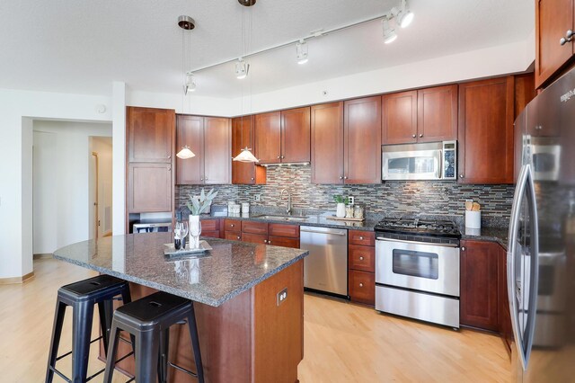 500 Grant St Unit 1302, Minneapolis, MN 55404 - kitchen with a center island, a sink, light wood-style flooring, appliances with stainless steel finishes, and backsplash