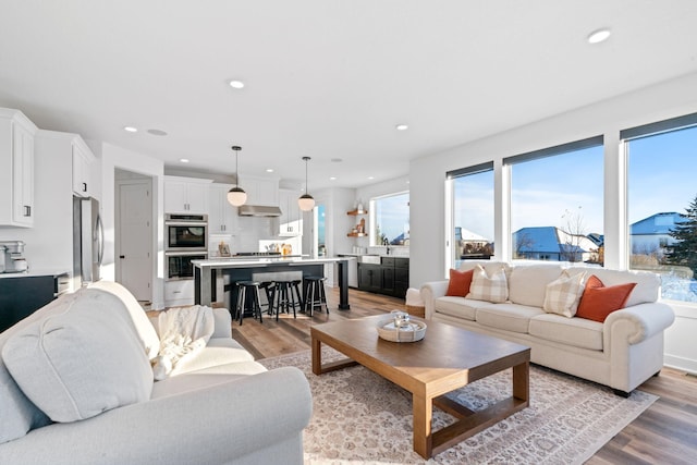 living area with recessed lighting and light wood finished floors