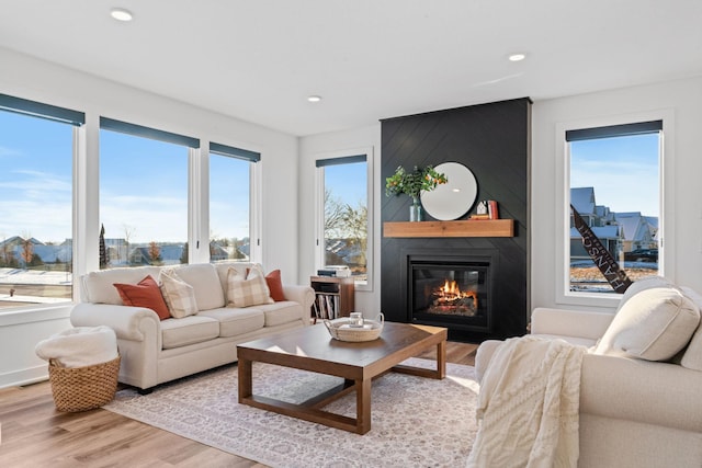 living area featuring recessed lighting, a fireplace, a wealth of natural light, and light wood-style floors