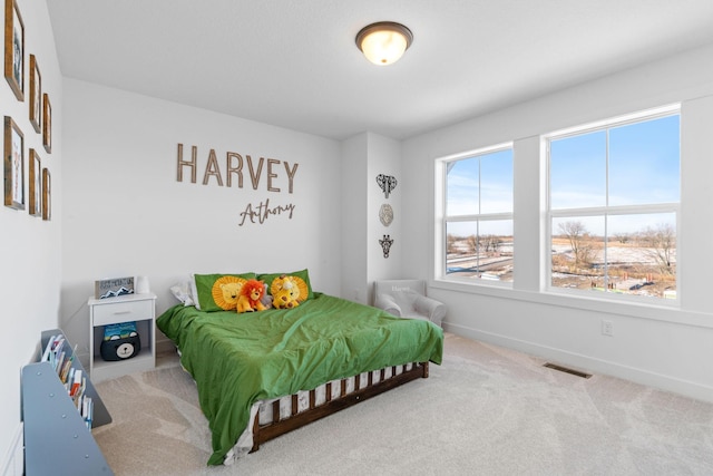 carpeted bedroom featuring visible vents and baseboards