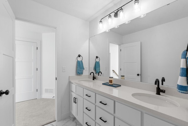 bathroom featuring double vanity, marble finish floor, visible vents, and a sink