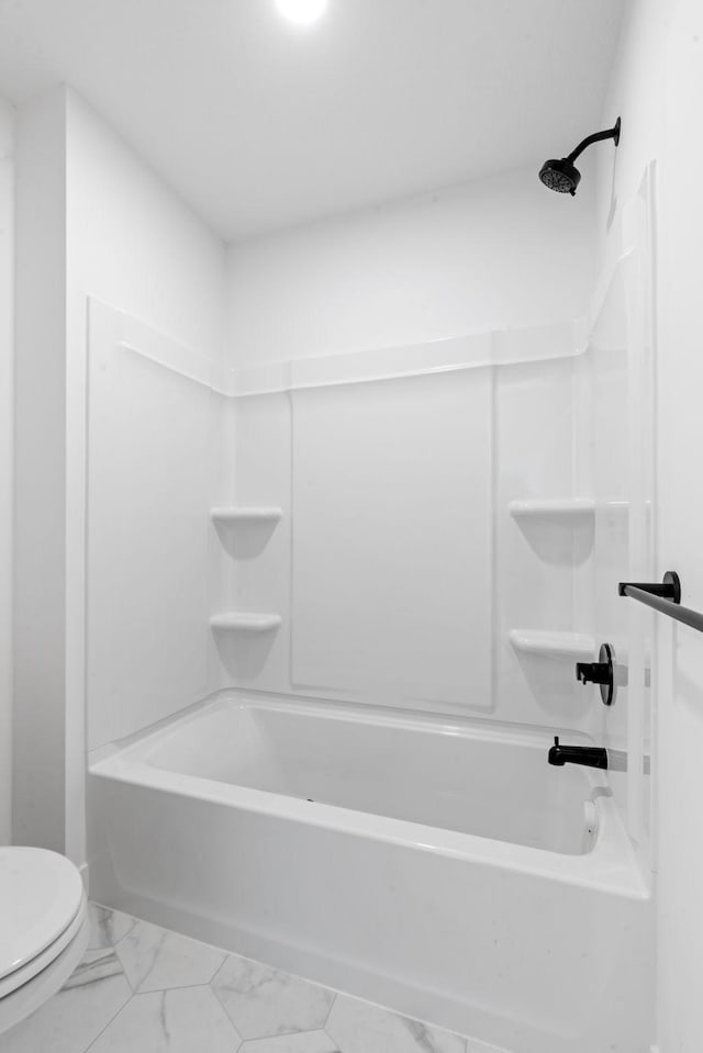 bathroom featuring  shower combination, marble finish floor, and toilet