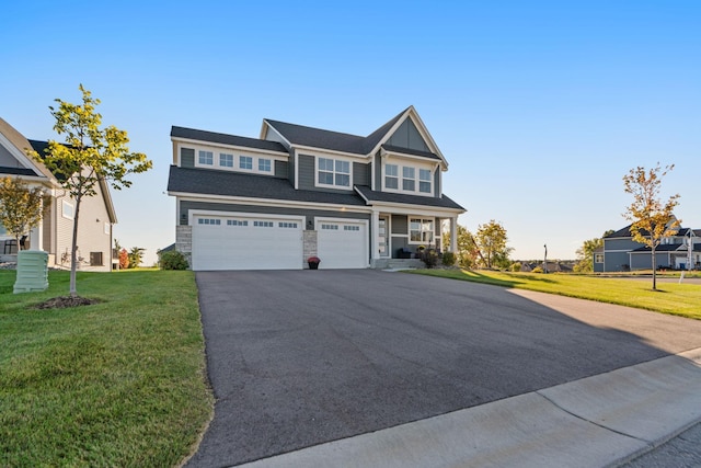 view of front of property with a garage, stone siding, driveway, and a front yard