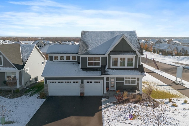 view of front facade featuring a garage, aphalt driveway, and a residential view