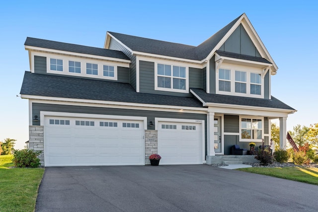 view of front facade featuring driveway, a porch, roof with shingles, and an attached garage