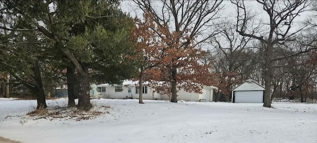 snowy yard featuring a detached garage