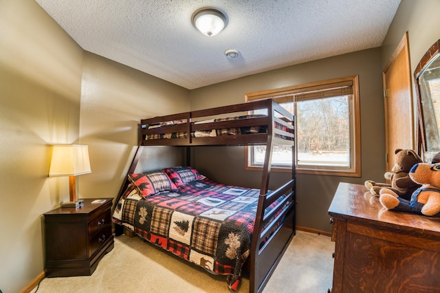 bedroom with light carpet, a textured ceiling, and baseboards