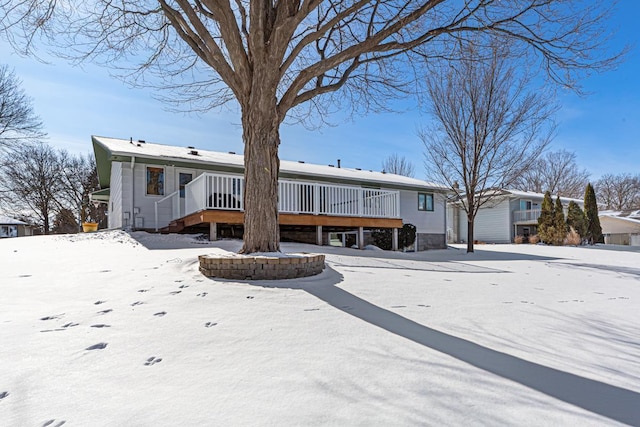 snow covered rear of property featuring a wooden deck