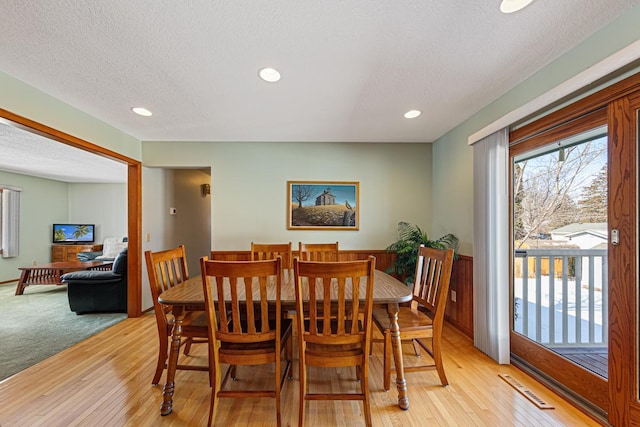 dining area featuring a wealth of natural light, visible vents, light wood-style flooring, and a textured ceiling